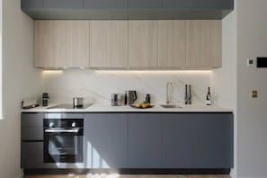 Open space with private kitchen area fully equipped with washing machine-dryer, oven, stove, kettle, toaster, dishwasher, Nespresso coffee machine, and kitchenware. Salt and pepper included. Non-included oils or food.