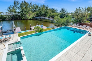 Relish in the tranquility of the hot tub and oversized heated pool featuring waterfront views in the privacy of the Mayan Lake.