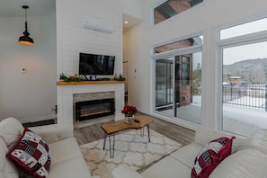 Bright living room with fireplace, large windows, and direct access to the
patio