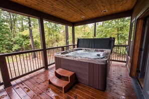 Our spacious hot tub on the deck overlooks the pines and natural scenery of Broken Bow.