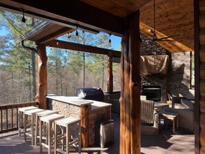 Experience outdoor luxury on our back deck: unwind by the cozy fireplace, catch the game on TV, and sizzle up delicious meals on the grill, all in one captivating space