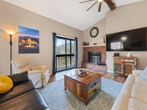 Open concept living room area with vast views of course below and the mountains.
