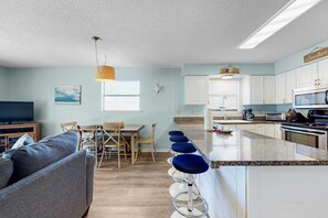 The wood-crafted dining table comfortably seats 6 guests, while the convenient breakfast bar provides additional seating for 4.