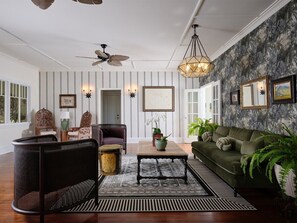 Step into timeless elegance—our lounge blends vintage tropical charm with lush textures and cozy seating. Perfect for relaxing with a good book or sharing stories over cocktails.