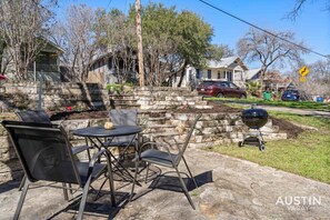 Patio in th front of the house with seating and grill