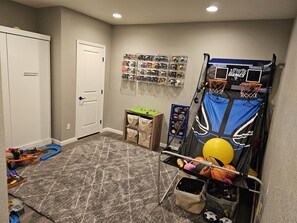 Game room with toys and Murphy bed in basement 