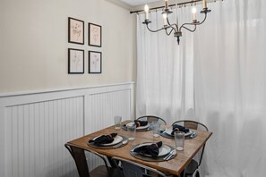 Eating area with dining table to seat 4 guests. Light and airy curtains. 