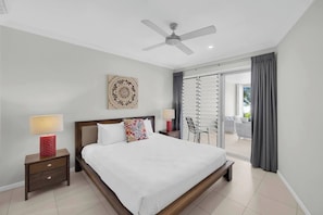 The primary bedroom offers a king-sized bed and connects to an open-air ensuite with a glass shower and jetted spa bath.