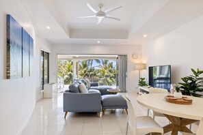 The living room features a chic sofa fronting a Smart TV with Netflix.