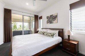 The primary bedroom offers a comfortable king-size bed, direct access to the balcony, and an ensuite with a spa bath.