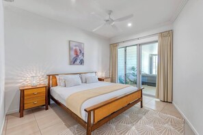 The primary bedroom offers a comfortable king bed under air-conditioning, an attached ensuite and opens up to the beachfront balcony.