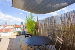 50 m2 terrace and dining area on the top floor of the building. View over the buldings of the Part Dieu business district