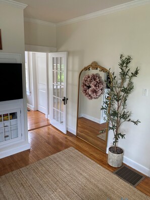 Beautiful living room with door leading the private work space/sun room.