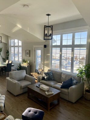 Open - living room, dining room and kitchen with 14' ceilings and wood floors.