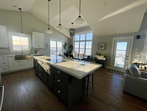 Open - living room, dining room and kitchen with 14' ceilings and wood floors. 