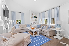 Living room with plenty of seating, fireplace (for decor), smart TV and vaulted ceiling