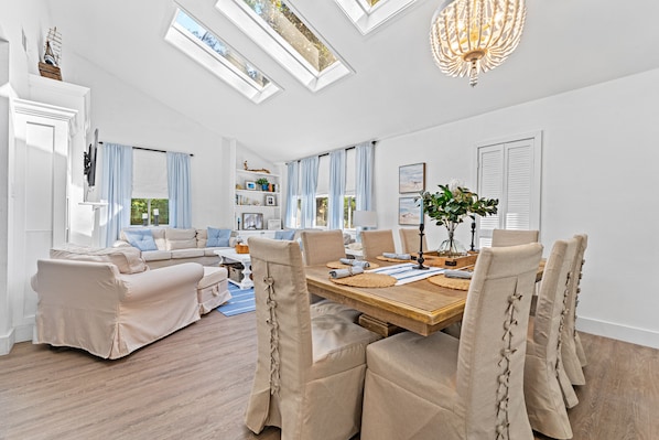 Open concept living and dining area with seating for 8 at the table and ample seating in living room with smart TV