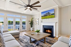 Relax in our cozy living room with a fireplace, large TV, and stunning lake views from the spacious seating area.