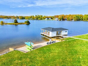 A scenic lakeside retreat with a private sandy beach, paddleboard storage, and a boathouse, perfect for outdoor fun and relaxation