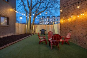 Shared backyard space with seating for 4, string lights, and a grill (please provide your own propane).