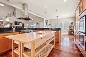 Fully-equipped kitchen with stainless steel appliances, double oven, two sinks, and large island