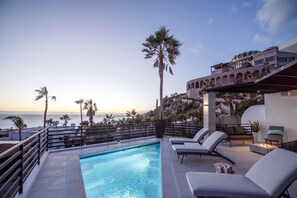 Poolside deck with lounge chairs and ocean views