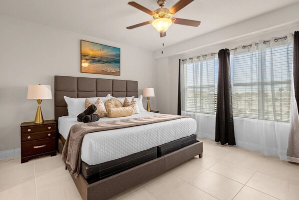 Master bedroom with ceiling fan and private TV. 