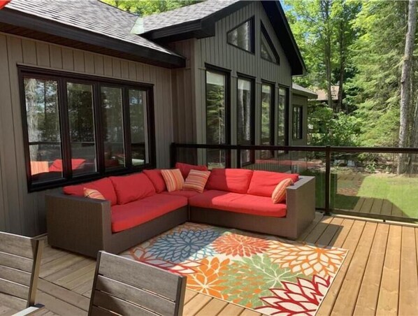 Spacious front deck overlooking the water. Includes couch, dining table and BBQ