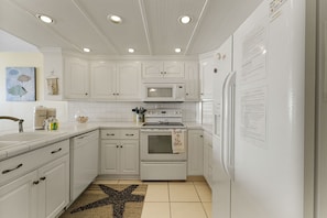 The kitchen is open and spacious. The tile counters allow for plenty of room for entertaining.