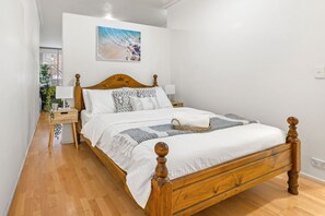 The bedroom area with a queen sized bed & plush pillows along with a privacy wall.