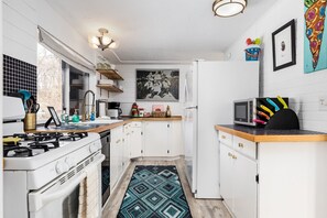 This fully equipped kitchen welcomes guests with modern appliances for their culinary adventures. From a sleek stove to a spacious fridge, it offers everything needed to whip up delicious meals in comfort and style.