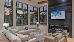 Modern main level great room with fireplace, TV, and view
