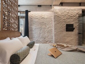 Elegant bedroom with king bed, textured walls, and lighting for restful nights.