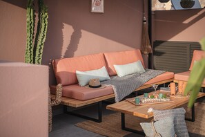 Rooftop lounge with warm tones, natural textures, and cozy details for relaxing.
