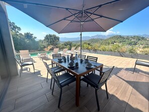 Terrasse avec coin repas et piscine 