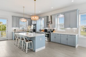 Large, open kitchen with huge island and bar stools 