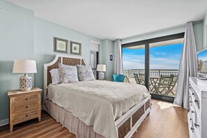 Master bedroom offers a queen bed with fresh linens + patio access w/ oceanfront views