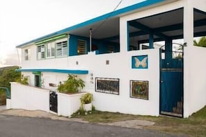 The entrance is located on the right side of the house with an individual gate.