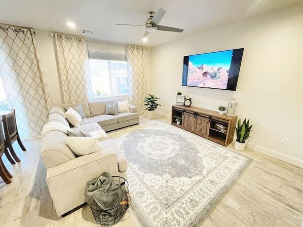 Relax in the living room while watching our 70" TV. The sectional offers a queen size pull out bed and bedding is in the tv stand.