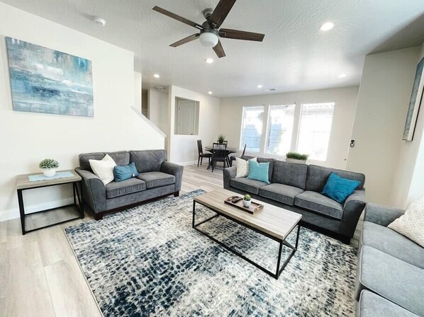 The living room has a 70" Samsung smart TV, seating for 8, a ceiling fan, and a 4-person game table. 