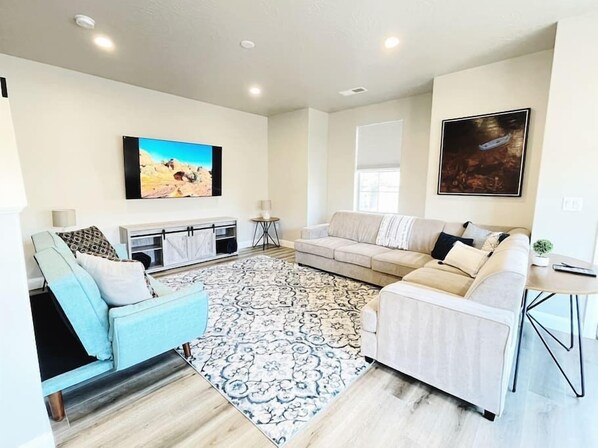 Relax in the living room while watching our 70" TV. The grey sectional offers a queen size pull out bed. 