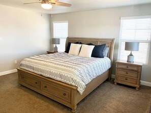 The master bedroom's king size bed with 2 nightstands and lamps.