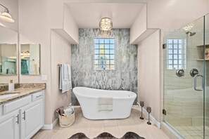 Experience indulgence in our master king suite bathroom, featuring the convenience of two sinks, a freestanding bathtub, and a spacious walk in glass shower.