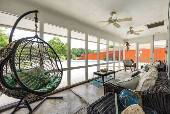 Beautiful sunroom with comfortable seating overlooking the backyard and private pool