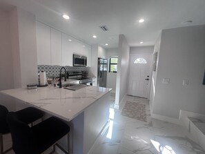 Front door view and kitchen to the left.