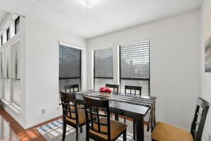 Spacious dining table for 6 with nature views through expansive windows. 