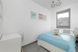 A cozy room with a comfortable double bed dressed in soft blue linens. 