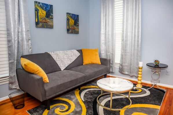 Relax in bedroom's 2 casual charm, with a plush couch, center table, and carpet.