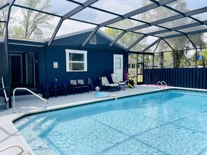 Large heated pool in fenced in yard overlooking river and preserved forest land.