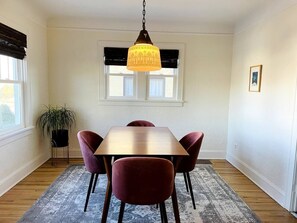Bright dining room with modern table and plush velvet chairs. Antique gothic light sets a cool mood.